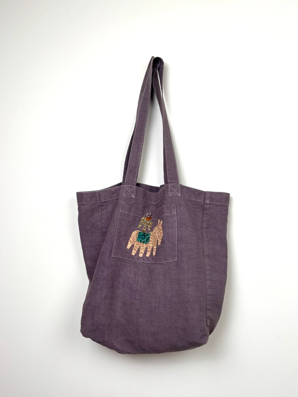 Yellow horse in a lilac dyed bag