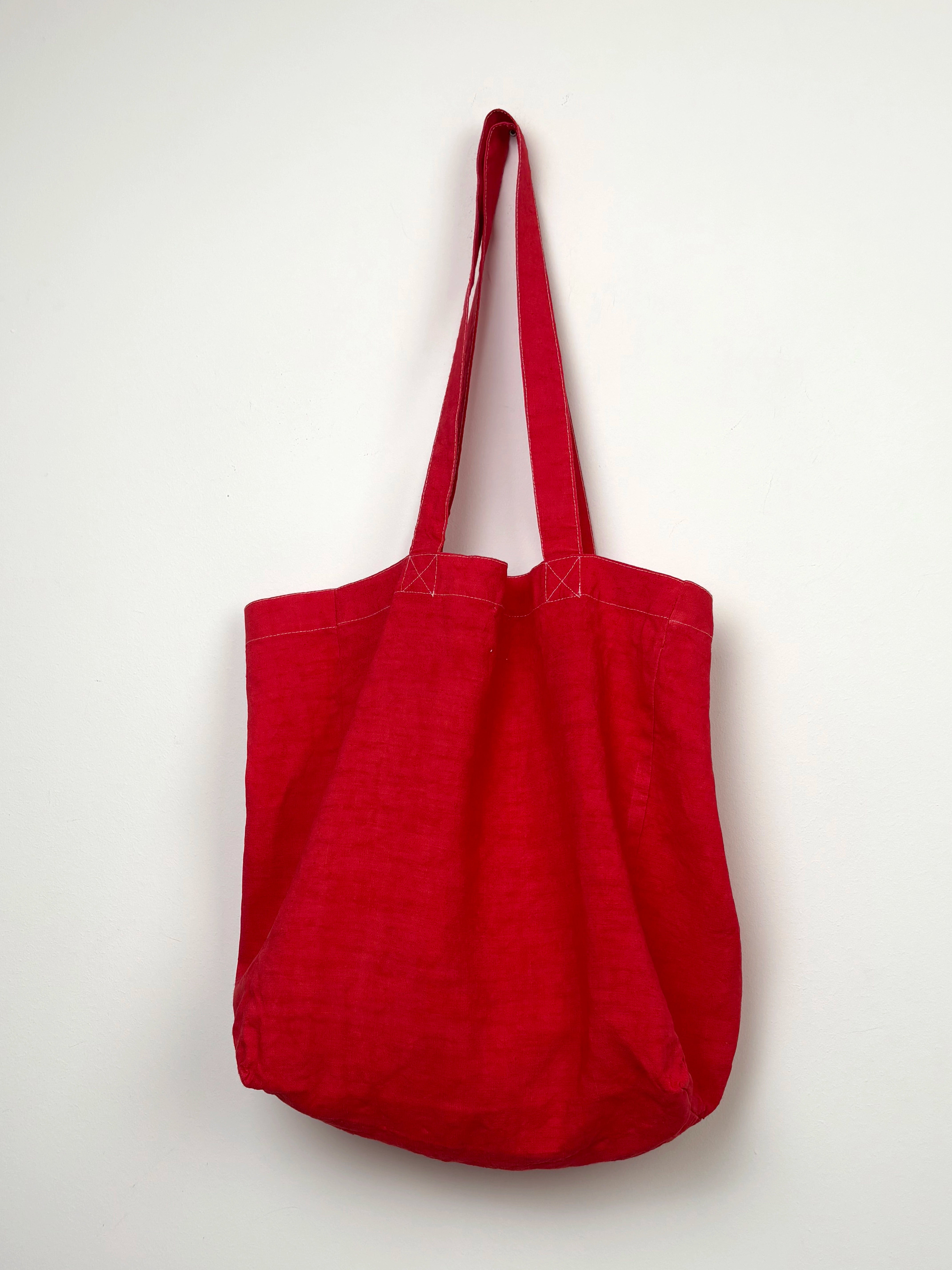 Grey horse in a red dyed bag