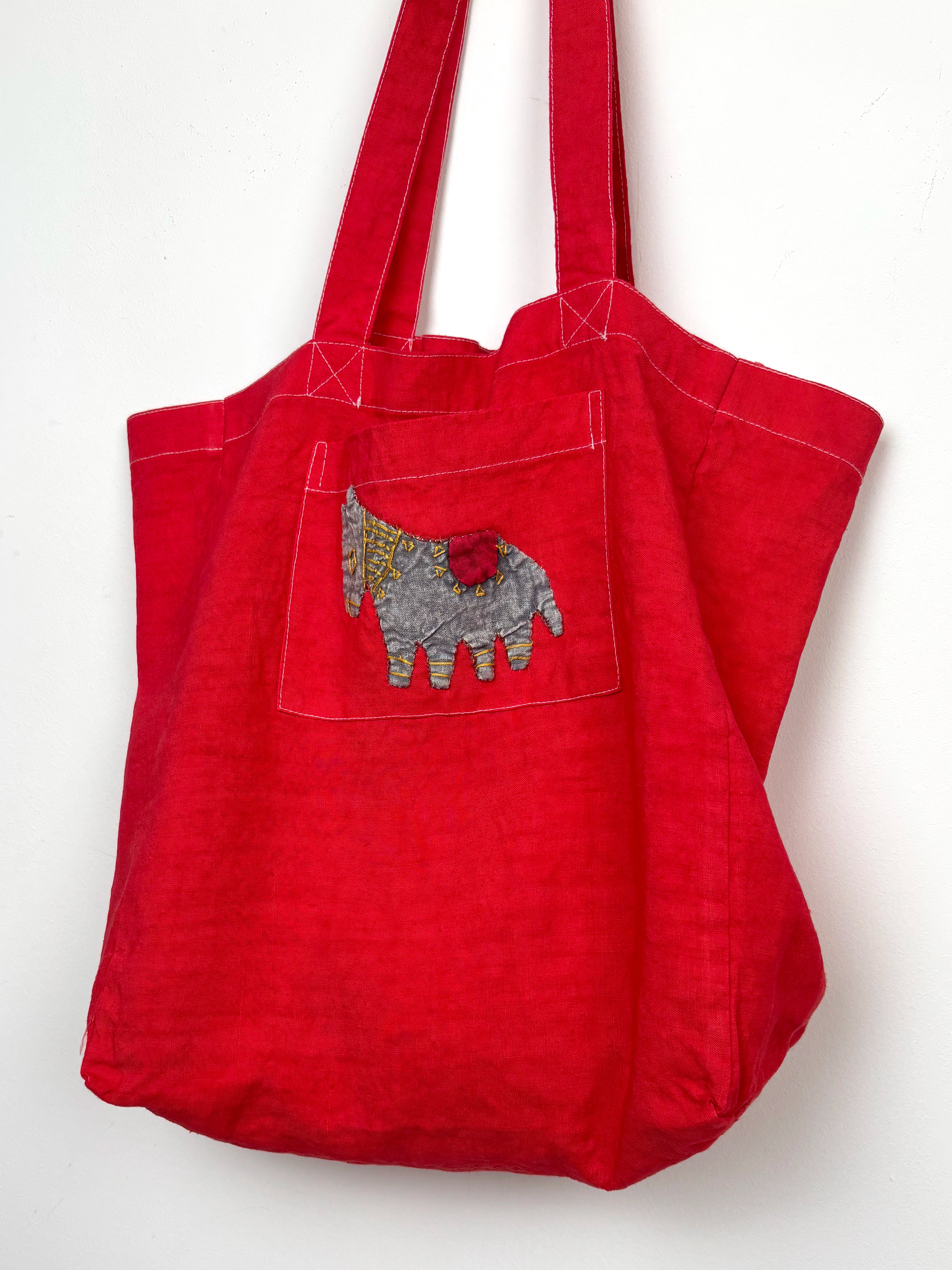 Grey horse in a red dyed bag