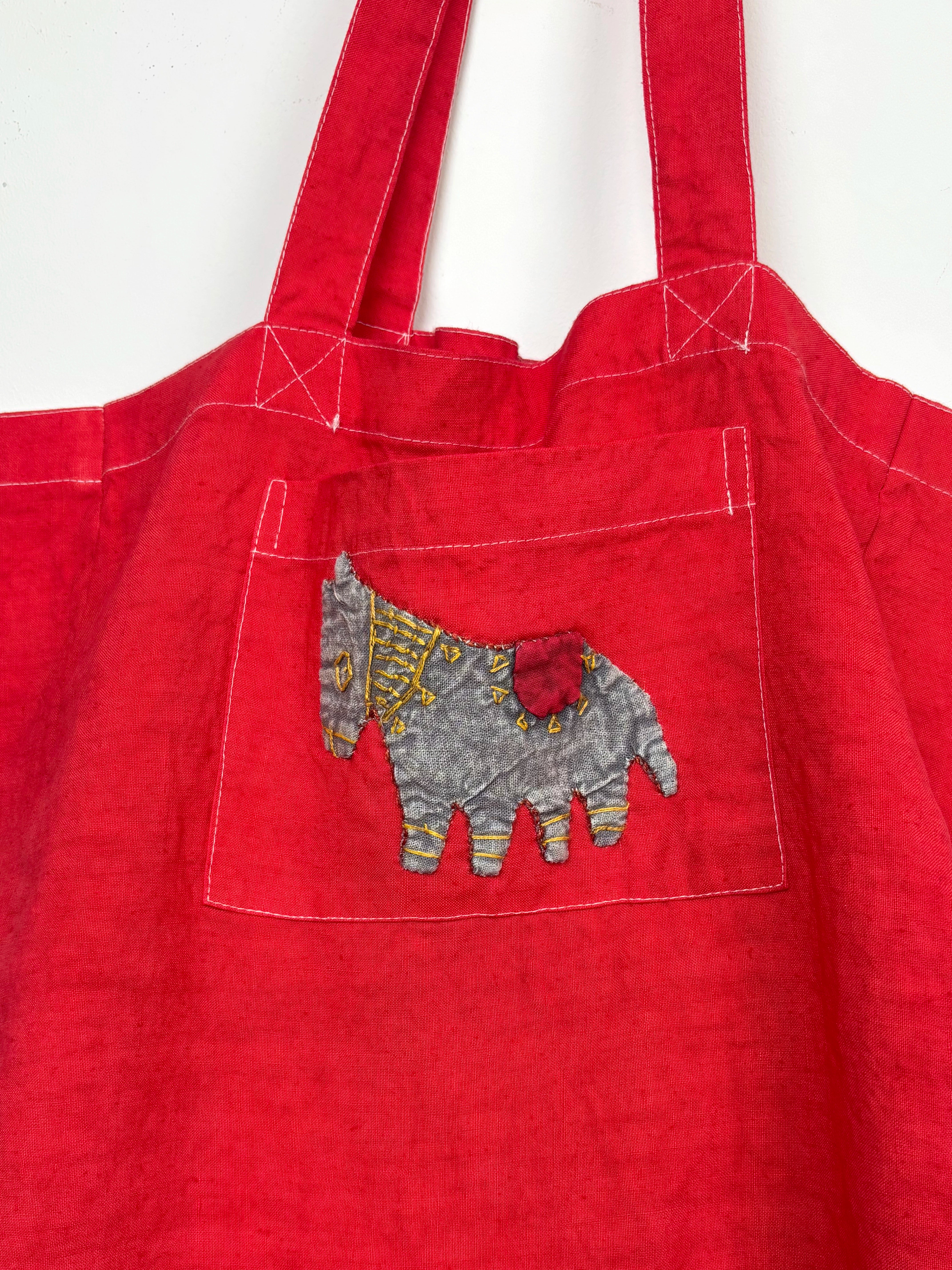 Grey horse in a red dyed bag