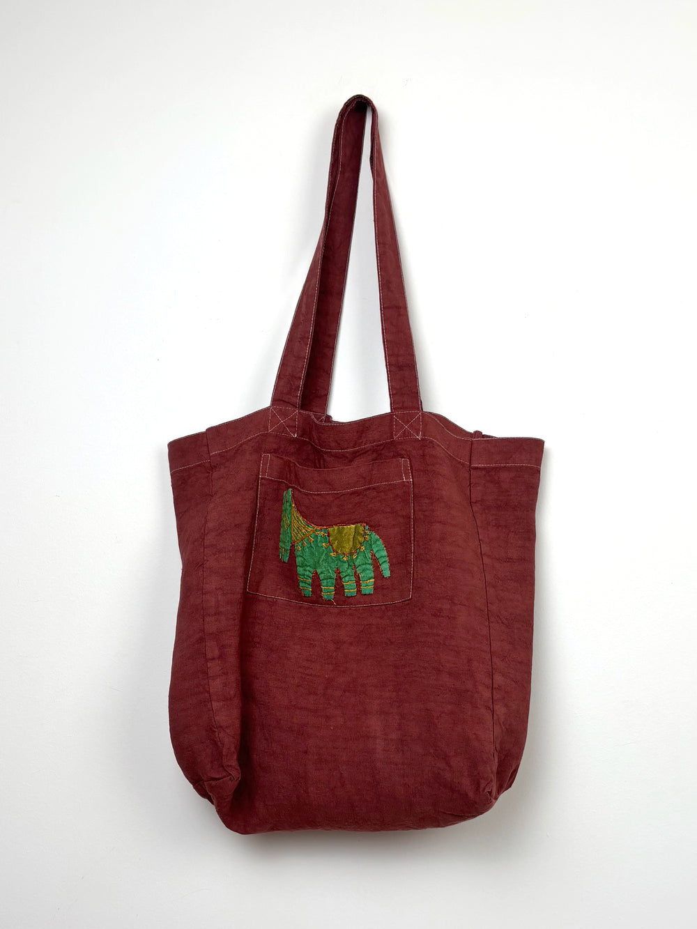Green horse in a terracota dyed bag